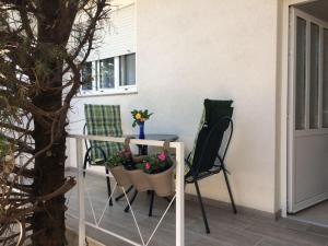 a porch with a table and chairs and a plant at Nadalina 10 in Starigrad