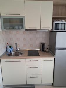 a white kitchen with a sink and a refrigerator at Nadalina 10 in Starigrad