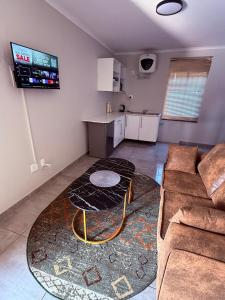 a living room with a couch and a kitchen at Ella Guest House in Pretoria