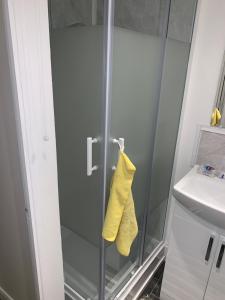 a shower stall with a yellow towel hanging from it at M Studio in Raynes Park