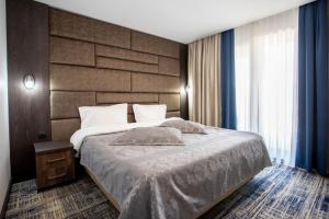 a bedroom with a large bed and a large window at Avenue Park Hotel in Yusufkhona