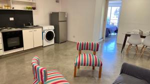 a living room with a kitchen and a stove and chairs at Departamento Martinez San Isidro con AA y Wifi velocidad Ideal para quienes necesitan alojarse cerca de clínicas como Trinidad San Isidro Las Lomas o Fertilitis excelente acceso desde Panamericana y Thames espacio comodo tranquilo y totalmente equipado in Martínez