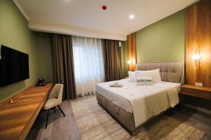 a hotel room with a bed and a desk at Sawei Urban Hotel in Craiova