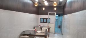 a room with a table and chairs and a blue door at Astha Restorent & Geust House in Aonla