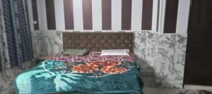 a bedroom with a bed with a blue comforter at Astha Restorent & Geust House in Aonla