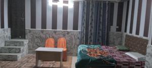 a bedroom with a bed and a table and a chair at Astha Restorent & Geust House in Aonla