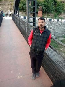 a man in a vest standing on a bridge at Astha Restorent & Geust House in Aonla