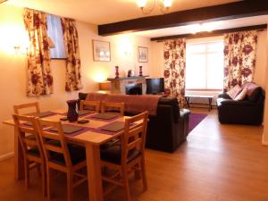 a living room with a table and chairs and a couch at Drws y Nant in Dolgellau