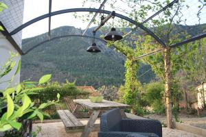 a patio with a table and chairs under a pergola at le balcon du Canigo' in Escaro