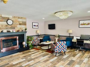 a living room with a fireplace and blue chairs at Quality Inn Raynham - Taunton in Raynham