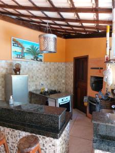 a kitchen with a stove and a refrigerator at Paraíso nas férias in Porto Seguro