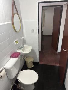 a bathroom with a toilet and a sink and a mirror at Jerarquizado M Rentals in Santiago del Estero +12 photos