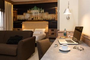 a hotel room with a bed and a desk with a laptop at Best Western Hotel Luxor in Turin