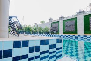 a swimming pool with a blue and white tiles at Nguem's Appart in Odza I
