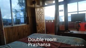 a bedroom with a bed and a large window at Homestay in Darjeeling By NE DEN in Jāmb