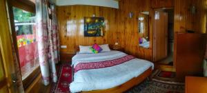 a bedroom with a bed in a wooden room at Homestay in Darjeeling By NE DEN in Jāmb