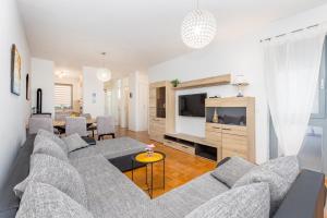 a living room with a couch and a tv at Apartman Dokić 3 in Vrbnik