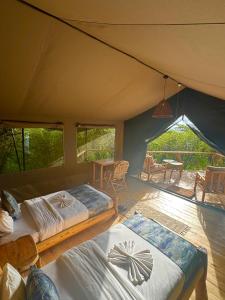 two beds in a tent with a table and chairs at Mara Hilltop in Sekenani +51 photos