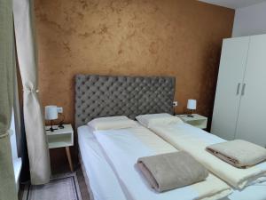 a bedroom with two beds with white sheets and two lamps at Six Windows Apartmani in Bačka Topola