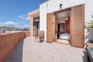 a balcony with wooden shutters on a building at Villa Geomare in Apolakkiá