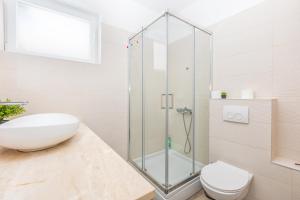 a bathroom with a glass shower and a toilet at Apartman Dokić 3 in Vrbnik +22 photos
