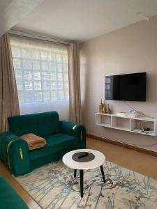a living room with a green couch and a coffee table at Esskayhomestays in Eldoret