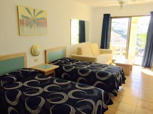 Habitación de hotel con cama y sofá en Studio Castle Harbour vistas piscina, en Los Cristianos