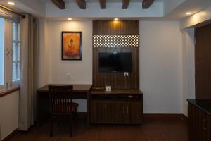 a living room with a desk and a television in a room at Fizzy Stay in Jawlakhel