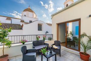 a balcony with chairs and tables on a building at Stentadì Guest House Tortolì in Tortolì