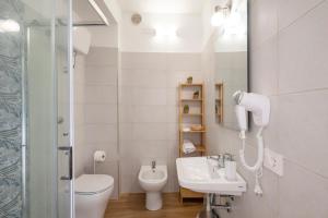 a bathroom with a sink and a toilet and a shower at Stentadì Guest House Tortolì in Tortolì
