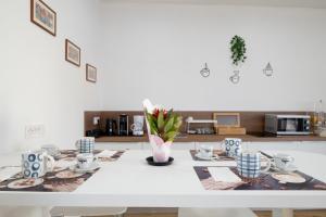 a kitchen with a white table with dishes on it at Stentadì Guest House Tortolì in Tortolì