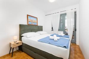 a bedroom with a large bed with towels on it at Apartman Dokić 3 in Vrbnik