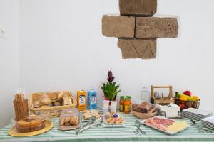 a table with bread and other foods on it at Stentadì Guest House Tortolì in Tortolì +10 photos