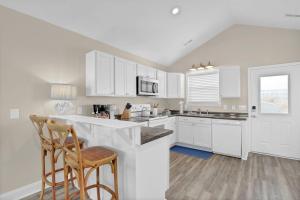 a kitchen with white cabinets and a counter top at Perched on the Dune In the Heart of Surf City in Surf City
