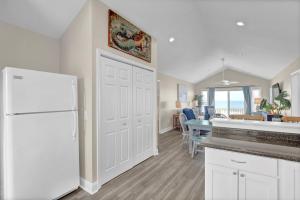 a kitchen and living room with a white refrigerator at Perched on the Dune In the Heart of Surf City in Surf City