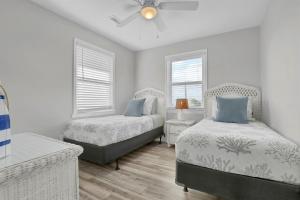 a bedroom with two beds and a ceiling fan at Perched on the Dune In the Heart of Surf City in Surf City +18 photos