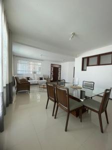 a living room with a glass table and chairs at Star HOUSE beach in Aracaju