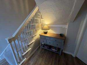 a staircase with a lamp on a dresser in a room at Rooftops in Louth