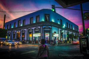 a woman walking down a street in front of a building at Hotel Plaza Iberia in Tehuacán +2 photos