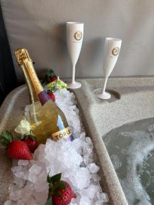 a champagne bottle and two wine glasses in a bath tub at Makárlux Vendégház in Pécs