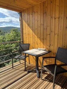 a table and two chairs on a wooden deck at Makárlux Vendégház in Pécs