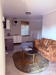 a living room with a couch and a table at Ella Guest House in Pretoria +13 photos