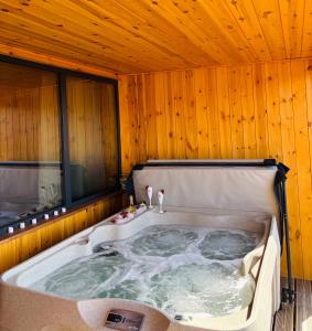 a jacuzzi tub in a room with wooden walls at Makárlux Vendégház in Pécs +19 photos