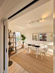 a living room with a white table and chairs at Vollmöbliertes Apartment am Deich in Neuendeich