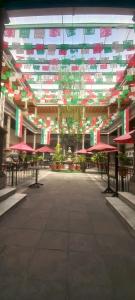 a large building with tables and red umbrellas at Hotel Plaza Iberia in Tehuacán