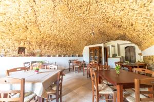 a dining room with tables and chairs and a stone wall at B&B Nonno Armando in Torchiara