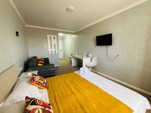 a bedroom with a bed with a yellow blanket at Halqyma Hotel in Oral