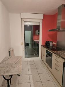 a kitchen with red walls and a table and a counter at La maison de Pommard in Dijon