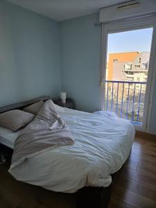 a bed in a room with a large window at La maison de Pommard in Dijon