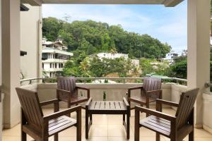 a balcony with chairs and a table and a view at Oak Ray Serene Garden Hotel in Kandy